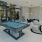 a room with a pool table and chairs