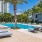 a pool with lounge chairs and palm trees by a building