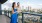 a man and woman posing for a picture on a balcony overlooking a city