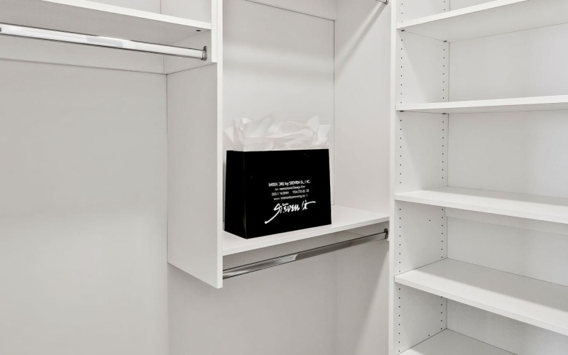 a closet with white shelves and walls