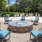 a group of chairs around a round fountain in a courtyard